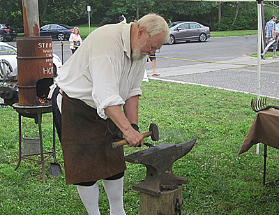 Blacksmith using anvil and hammer