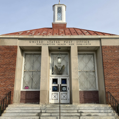 Facade of the United States Post Office in Westhampton Beach, New York, featuring a brick exterior, a copper roof, and an eagle emblem above the entrance.